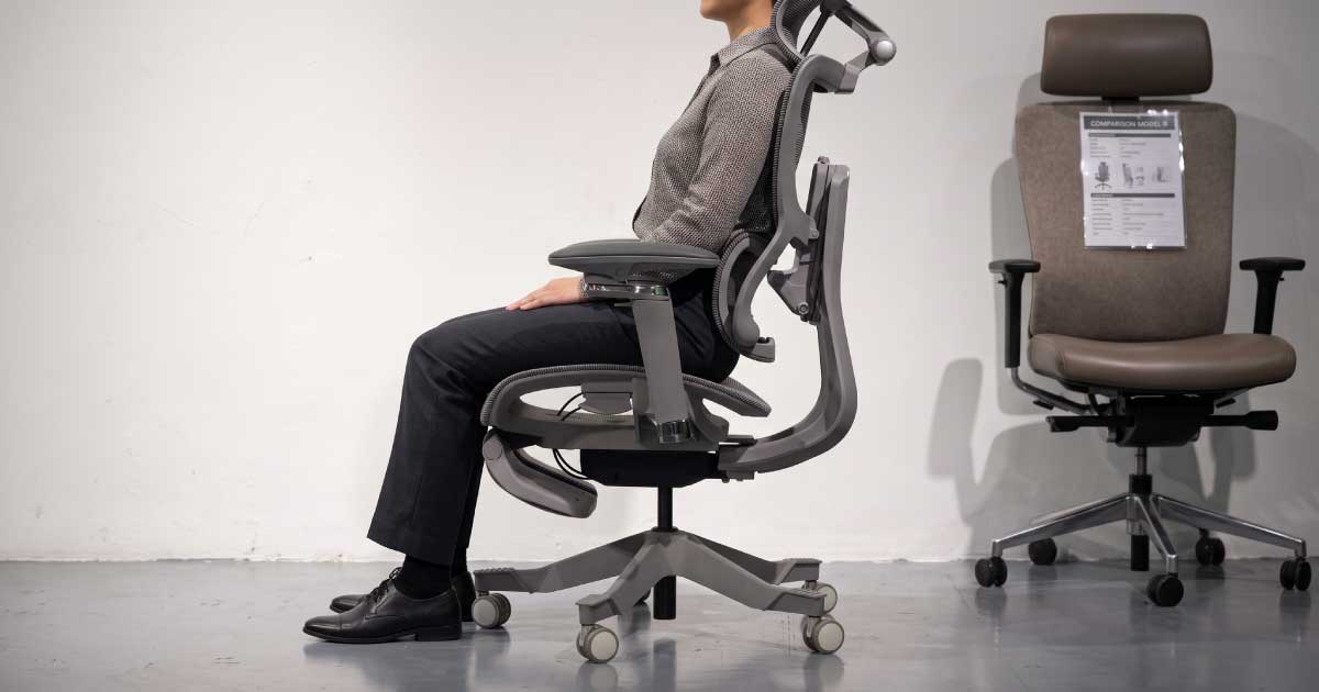 Person testing body fit and lumbar support in an ergonomic chair before buying