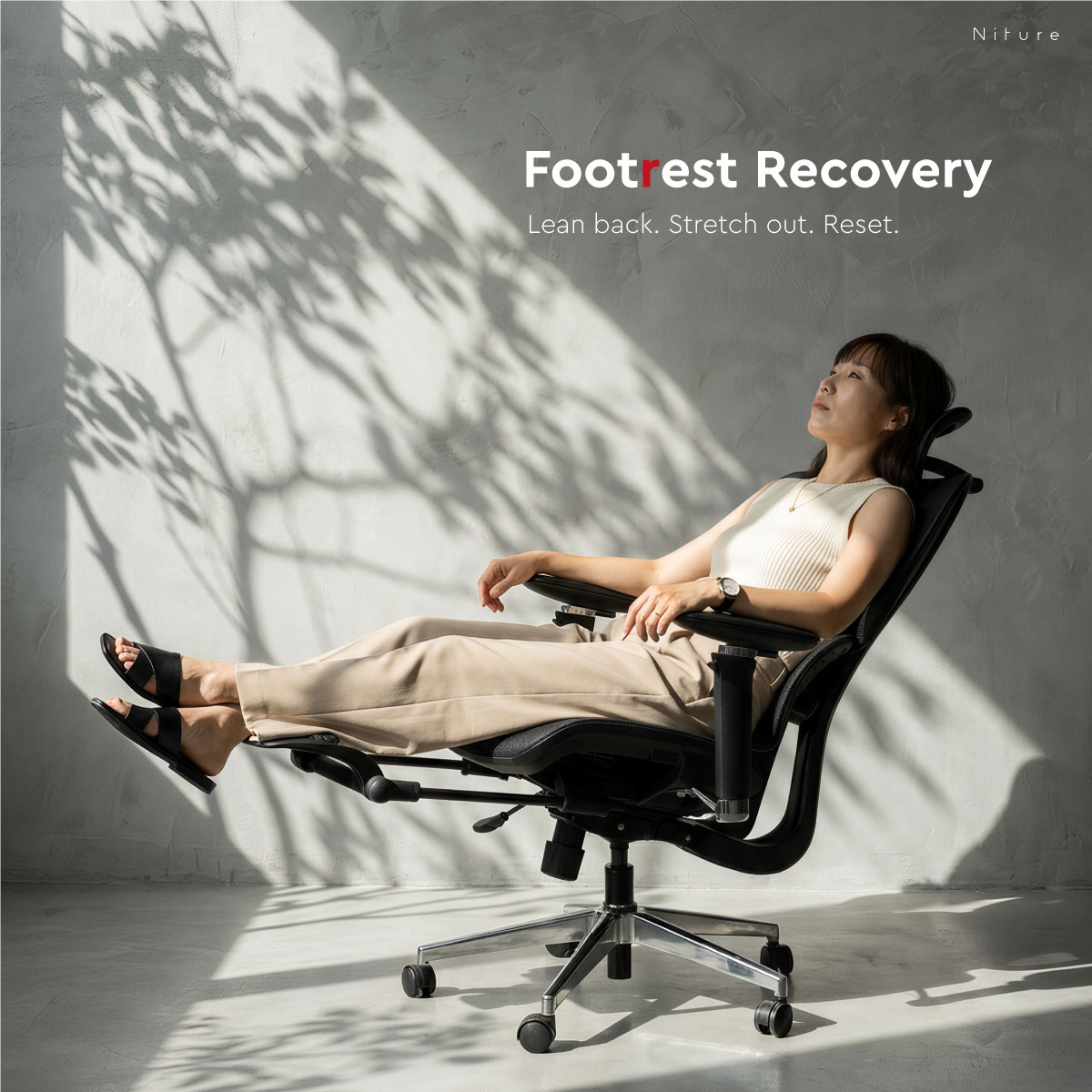 Person reclining in the Hammock 2 chair with the retractable footrest extended